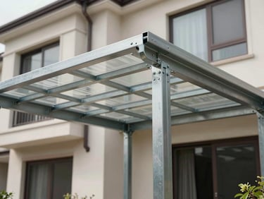 Environmental wide shot of a completed steel-frame canopy structure attached to a residential building exterior, natural daylight, anchor bolts and frame joints visible at corners