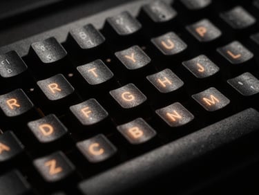 Extreme close-up of a rugged mechanical keyboard under harsh single-source amber terminal glow, deep shadows, 35mm film style