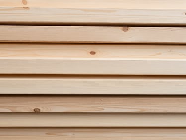 Overhead flat-lay of kiln-dried alder planks arranged in a tight bundle, close detail showing pale grain and smooth surface finish, even neutral daylight rendering colour and texture accurately, no people