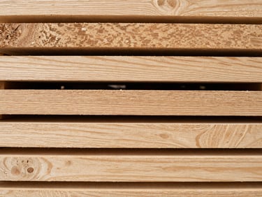 Extreme close-up overhead flat-lay of kiln-dried alder planks arranged in a tight stack — grain detail sharp and visible, pale warm surface tones, even neutral daylight, no shadow theatrics. No people, no text.