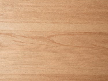 Extreme close-up overhead flat-lay of alder timber board surface under even neutral daylight, fine even grain structure visible across the full frame, warm pale reddish-brown tone, no figures, no text