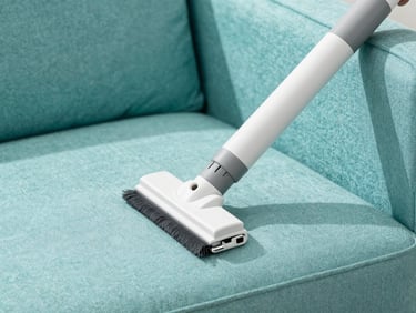 Professional cleaning equipment nozzle extracting deep dirt from a modern teal fabric sofa, high-key clean lighting.