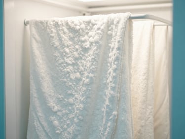 Close-up of fluffy white clean blankets hanging in an antibacterial drying room with soft warm light.