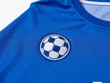 Close-up of clean custom embroidery on a blue athletic jersey, bright studio lighting
