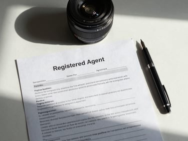 Overhead flat-lay of a printed registered agent service agreement on a minimal white desk, fountain pen beside it, cool north light