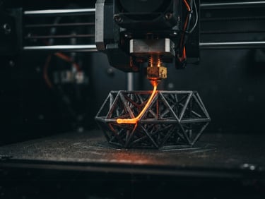 Macro shot of a 3D printer nozzle extruding molten orange filament, creating a complex geometric object, with a subtle digital grid overlay, low-key dramatic lighting, deep charcoal tones, cinematic industrial photography.