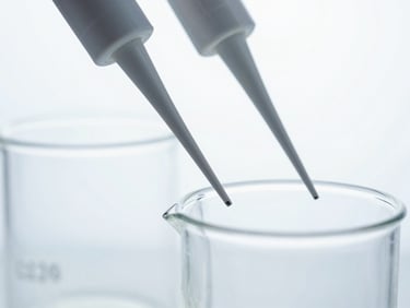 Macro close-up of sterile laboratory glassware and precision pipettes under crisp white studio light, cool tones, no human presence.