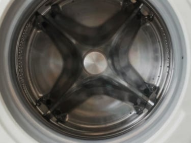 Close-up of a stainless steel washing machine drum spindle, clean metallic textures, neutral lighting.