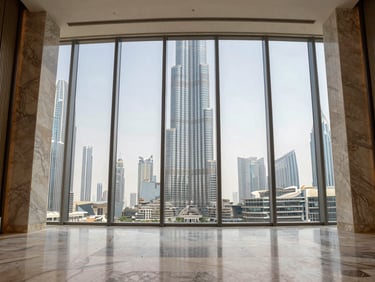 Wide-angle interior entry corridor of a Downtown Dubai penthouse, polished marble floors, floor-to-ceiling glazing, Burj Khalifa visible in mid-distance, natural daylight