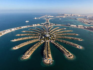 Panoramic aerial view of Palm Jumeirah from altitude, the frond geometry visible below, deep blue Gulf water surrounding the structure, shot in clear midday light with the coastline receding toward the horizon