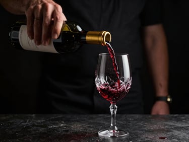 A sommelier pouring deep red wine into a crystal glass, low-key dramatic lighting, dark background
