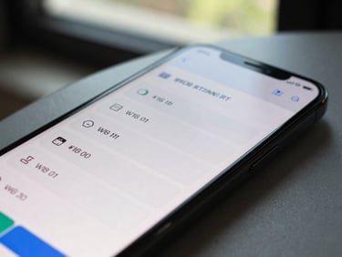 Close-up of an Android phone screen showing a local service booking app with time-slot selection UI, natural daylight from a window, device resting on a desk