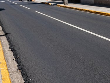 Wide-angle shot of a newly paved municipal avenue in Santiago, clean asphalt and road markings, bright daylight, industrial editorial style