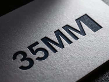 Close-up of premium physical branding on embossed heavy paper, sharp architectural shadows, 35mm