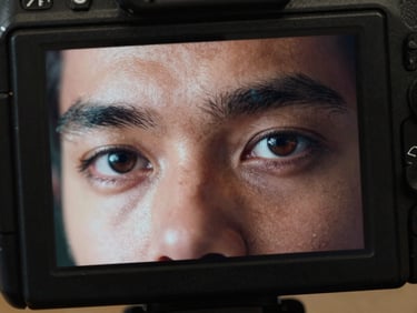 Extreme close-up of a professional camera monitor displaying a high-contrast human face with expressive eyes, cinematic lighting.