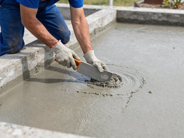 Professional technician applying a grey cementitious waterproofing slurry to a concrete foundation wall, sharp focus, natural outdoor light