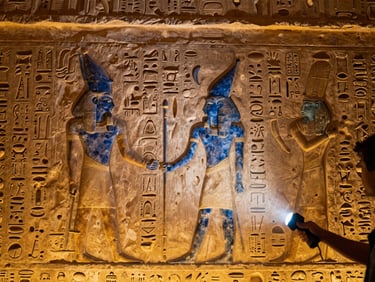Close-up of intricate hieroglyphs on an ancient temple wall, illuminated by a guide's flashlight in a private tour, showing fine detail and texture, warm light.