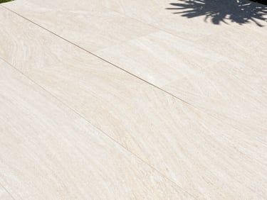 Overhead geometric flat-lay of a modern limestone patio layout with sharp joint alignments, casting crisp shadows.