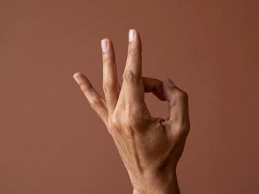 Close-up of a dancer's hands forming a single mudra, fingers precisely extended, warm north light catching the knuckle lines against a terracotta-toned wall