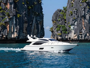 A sleek private yacht cruising past the dramatic limestone cliffs of Langkawi, clear blue water, bright high-contrast daylight.