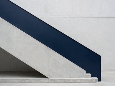 Minimalist concrete staircase in a modern corporate headquarters, clean lines, muted blue shadows, soft overcast lighting.