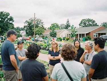 Wide street-level documentary shot of a neighborhood community garden meeting under overcast daylight, candid residents talking, 35mm grain
