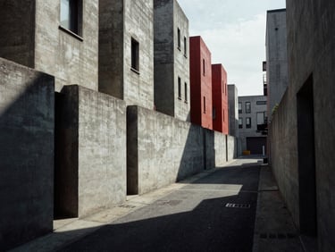 Stark architectural shot of a residential alleyway with high concrete walls, deep shadows, desaturated tones.