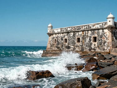 Bright daylight photo of the historic Forte São Mateus in Cabo Frio, with turquoise ocean water crashing on the rocks under a clear blue sky.