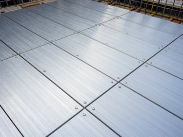 Overhead perspective of aluminum formwork panels laid out on a construction site floor, geometric grid of panels ready for concrete pour, daylight, detail of locking pins visible