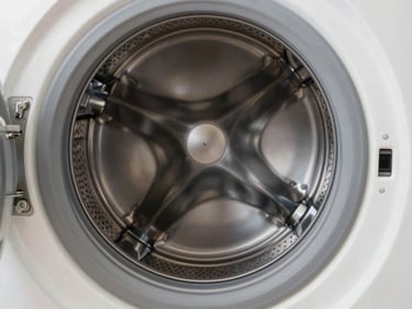 Close-up of a modern front-load washing machine drum with clean metallic texture, bright soft lighting