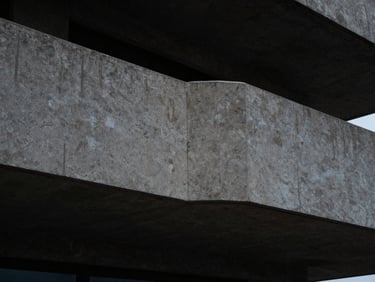 Precision joint sealing on an external concrete balcony, sharp material details, coastal architectural background.