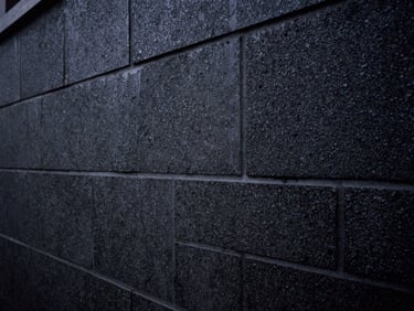 Masonry wall undergoing rising damp chemical injection, technical structural detail, low-key lighting.