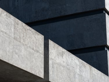 Abstract architectural detail of a modern secure government facility, sharp geometric concrete lines, cool slate and deep navy tones, high contrast, 35mm