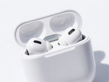 Close-up of sleek white wireless earbuds in their charging case on a clean white surface, bright high-key product photography, crisp natural daylight, vivid colors, sharp focus, 35mm