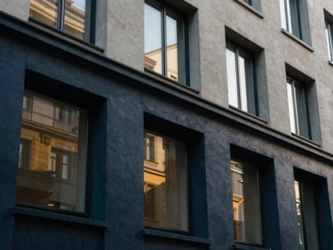An elegant architectural close-up of a modern Swiss banking pavilion facade, clean lines, soft natural window light, deep navy shadows and warm gold reflections, 35mm