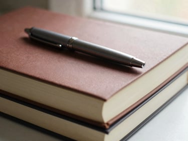 Stack of custom-branded matte paper notebooks with a premium pen, soft natural window light, rich textured tones, shallow depth of field, 35mm