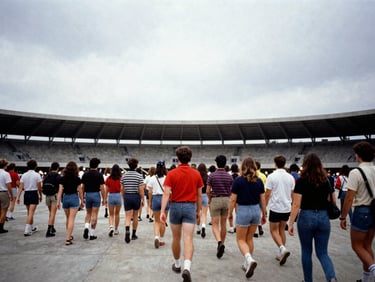 Candid 35mm photo of fans walking towards a concrete stadium under overcast sky, vintage styling, heavy grain, direct flash