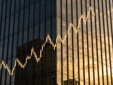 Abstract image of financial charts overlaid on a modern building facade, reflecting golden light, sharp focus.