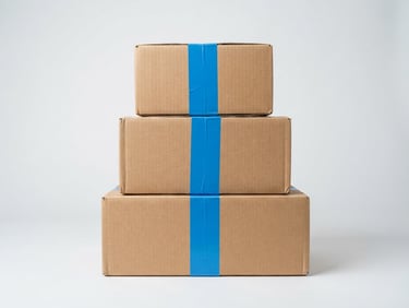 bright high-key product photography, clean light gray background, even studio lighting, sharp focus, 50mm, a neat stack of cardboard shipping boxes with a vibrant blue shipping tape