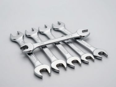Clean close-up of a chrome wrench set and car care products on a neutral background