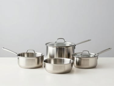 Minimalist kitchenware set with stainless steel pans on a bright counter