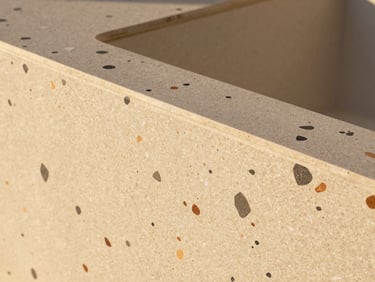 Close-up of custom terrazzo tile with local volcanic stone aggregate, matte finish, architectural detail.