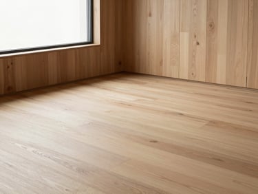 Wide architectural interior showing a light bleached wood floor bathed in natural light, clean modernist aesthetic.