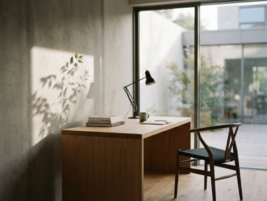 Minimalist editorial photography of a quiet, sunlit architectural office space with soft shadows on a concrete wall, indirect daylight, 35mm