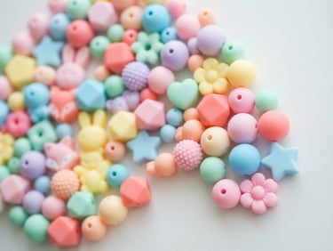Bright flatlay of various candy-colored silicone beads arranged in a playful pattern, soft natural daylight, shallow depth of field, clean matte textures, off-center to the right, vibrant and inviting.