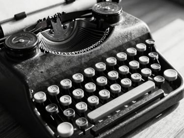 High-contrast black and white close-up of a vintage mechanical typewriter, keys heavily worn, harsh directional light casting long shadows across a stack of papers.