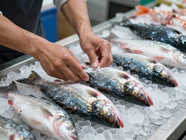 Hands of a fishmonger arranging whole fish on a bed of crushed ice at a market counter, cool north-facing daylight, no warm correction, close framing showing only hands and product
