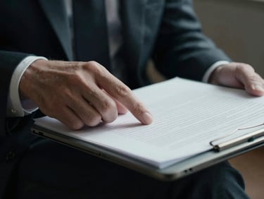 Close-up of a founder's hand, wearing a subtle, dark suit, reviewing redacted case files on a tablet, dramatic side-lighting, cool desaturated tones, high contrast, tight crop, 35mm film.