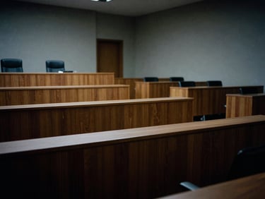 Clean architectural lines of a modern, empty courtroom, dramatic side-lighting, cool desaturated tones, high contrast, suggesting precision and impartiality, 35mm film.