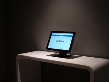 Moody low-key shot of a boutique hotel lobby, a glowing digital concierge screen on a minimalist desk, electric blue light accents, 35mm